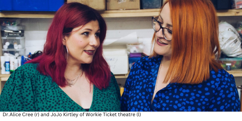 Two women are stood next to each other looking at each other, one has orange hair and is wearing glasses, this is Dr Alice Cree, the other has red hair and is JoJo Kirtley